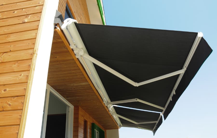 High-quality retractable awning on the window of a modern wood house